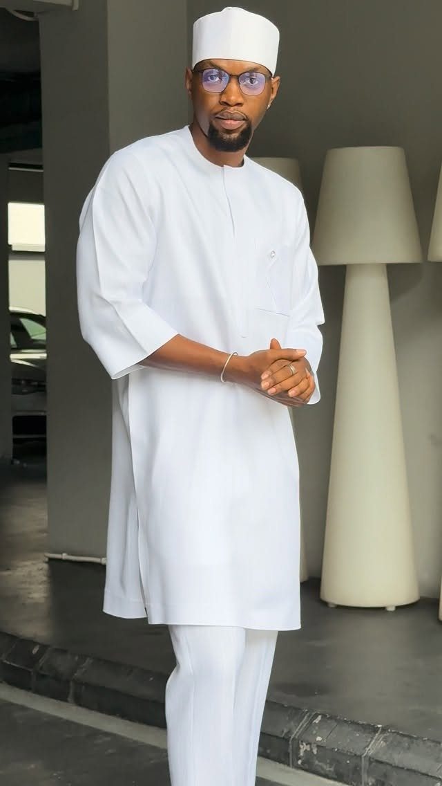 Man in a traditional all white outfit including a tunic and kufi cap.
