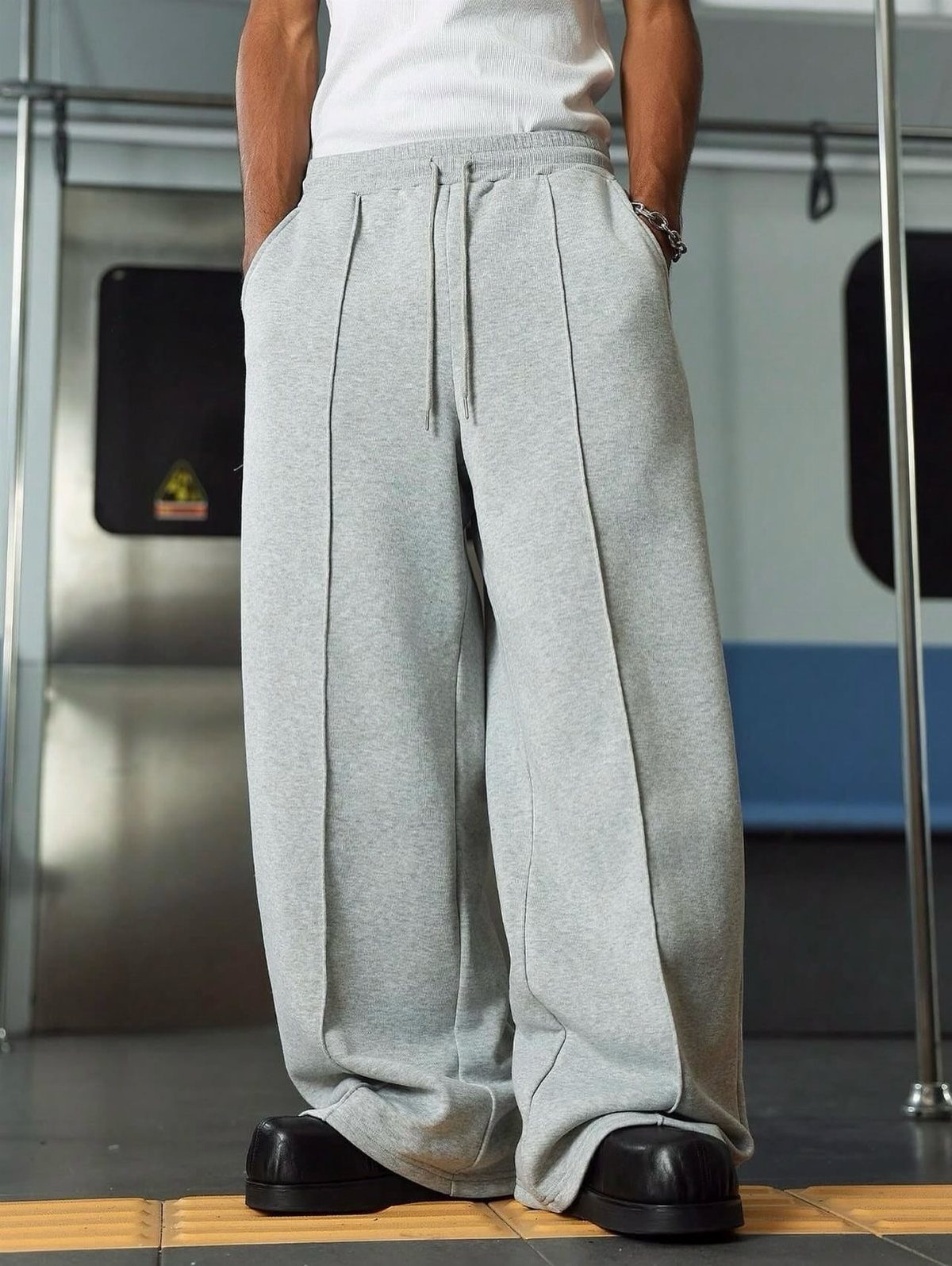 Wide-leg grey drawstring trousers with pleats paired with a white t-shirt.