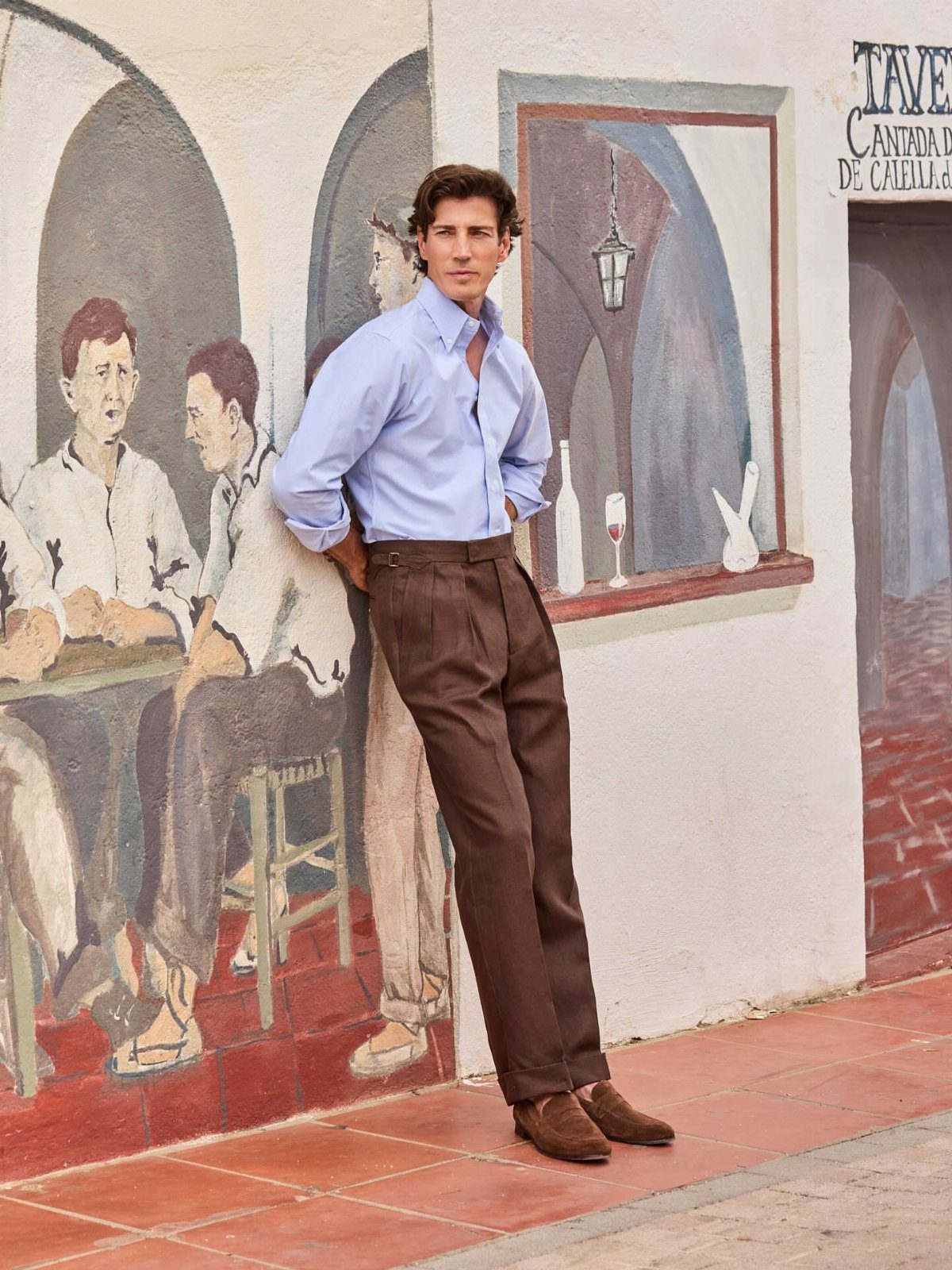 Man wearing a light blue shirt, brown trousers, and brown suede loafers.