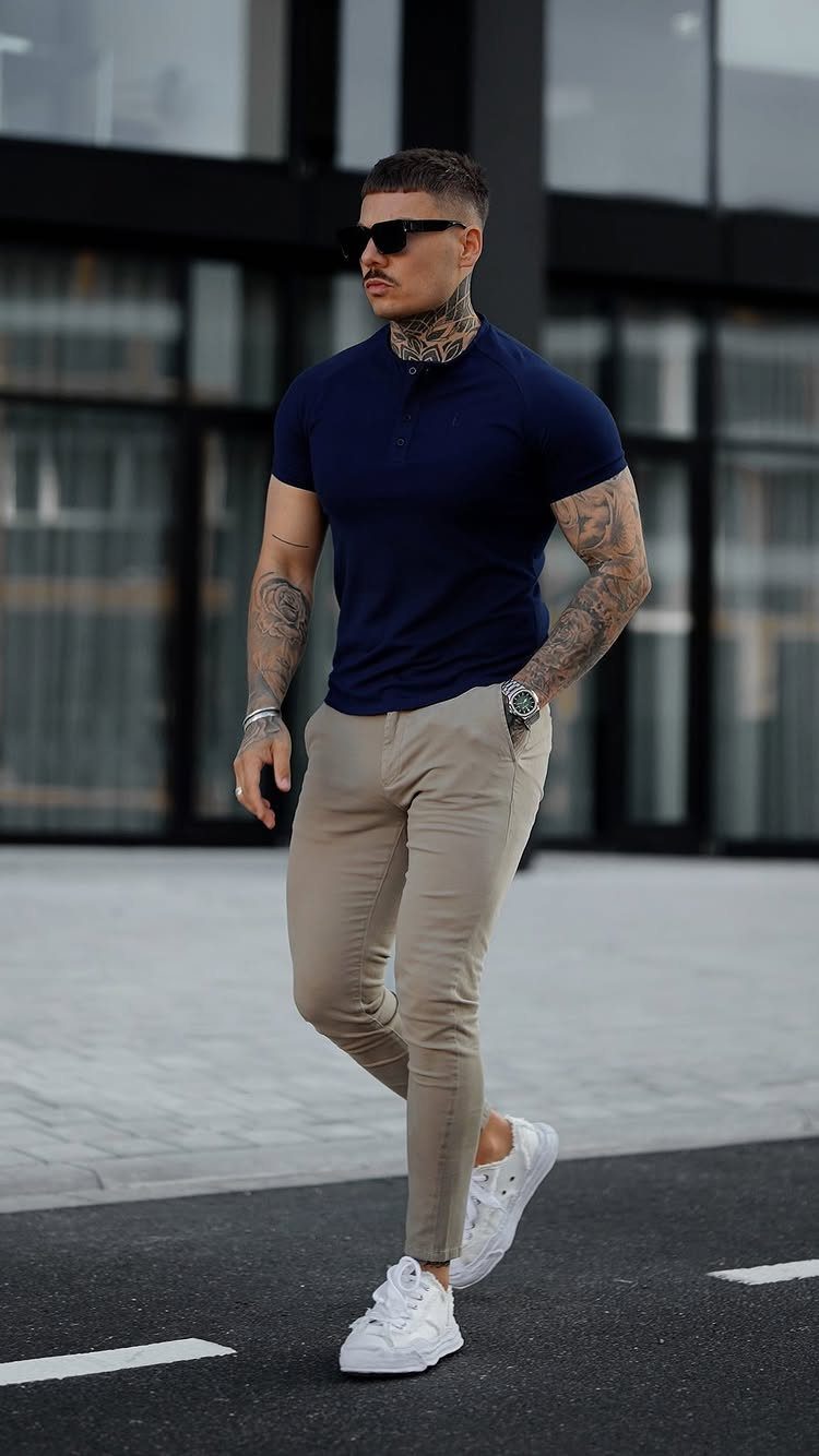 Man wearing a navy polo shirt and beige slim-fit chinos with white sneakers.