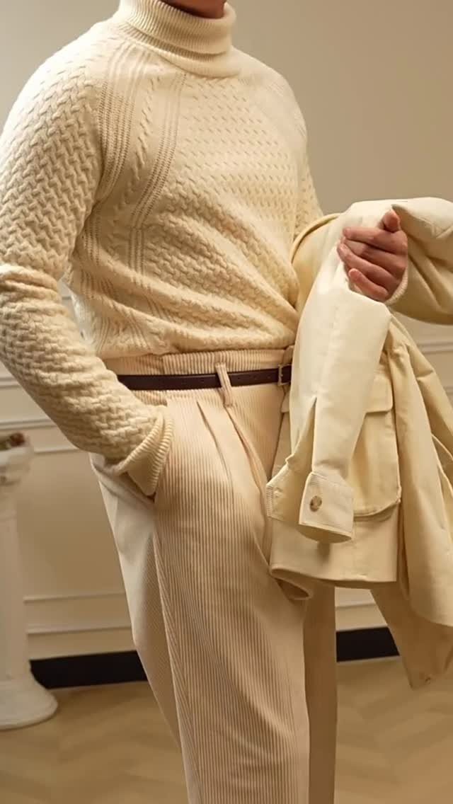 Person wearing cream cable-knit turtleneck and tailored cream corduroy trousers with brown belt.