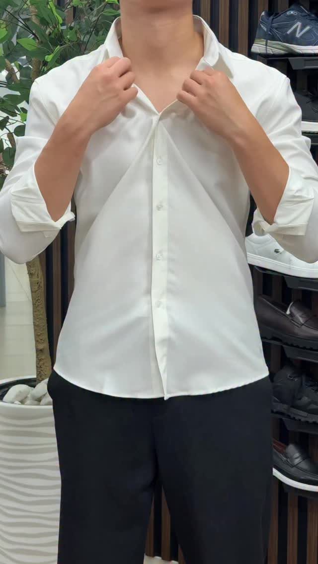 Person wearing a crisp white button-down shirt and black trousers in a store