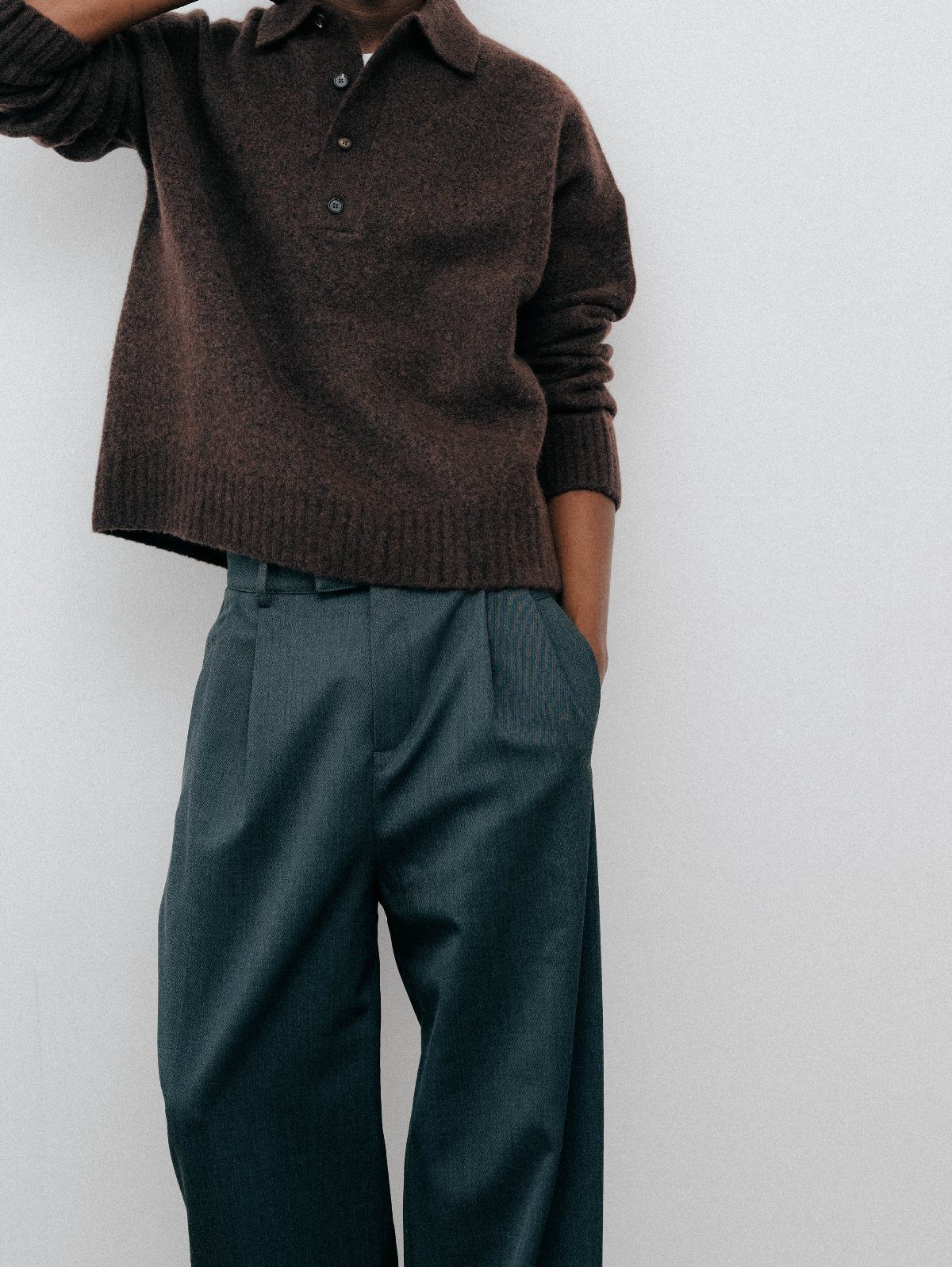 Brown fuzzy cropped knit polo sweater paired with wide-leg dark teal trousers.