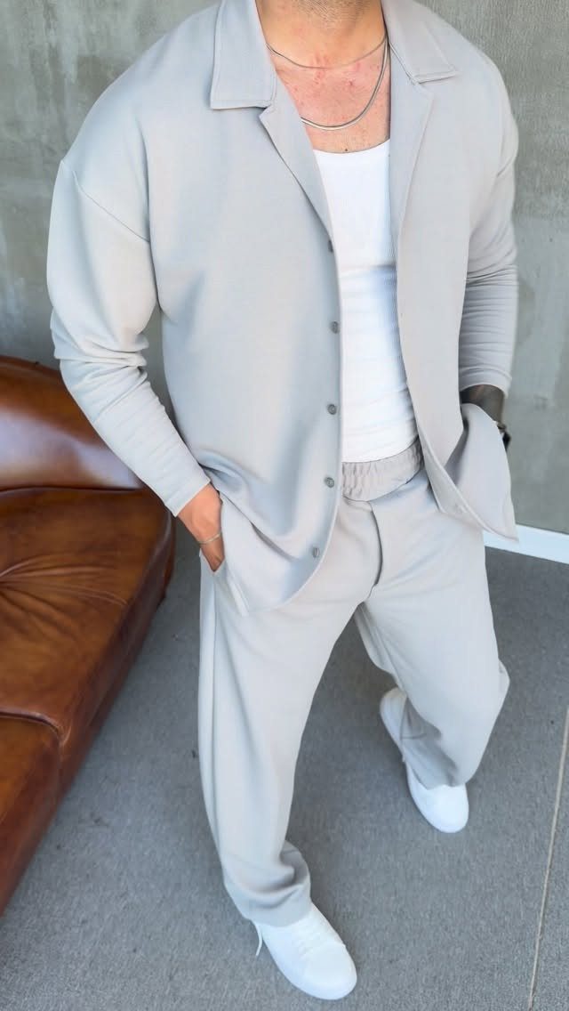 Man in a light grey casual set with white t-shirt and white sneakers.
