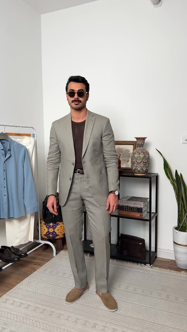 Man wearing a light grey linen suit with a brown t-shirt and loafers.
