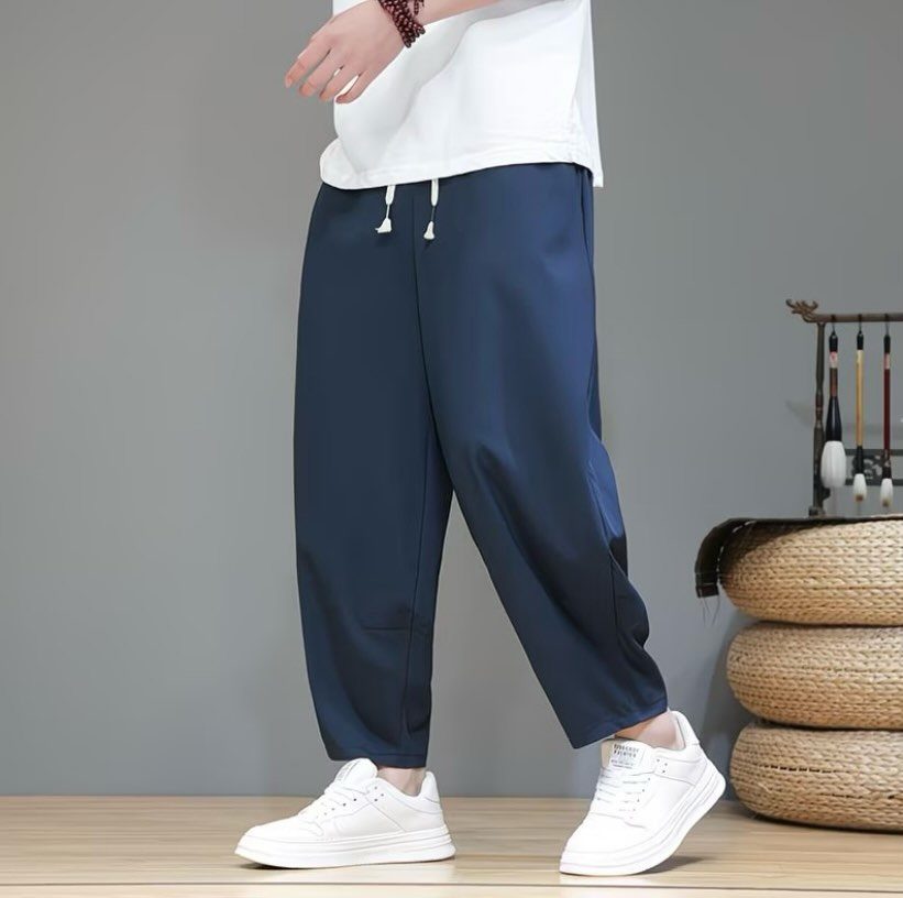Navy blue drawstring waistband pants paired with a white t-shirt and white sneakers.