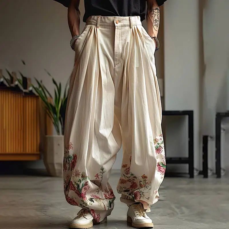 Oversized cream pleated trousers with floral patterns on the lower legs and white shoes.