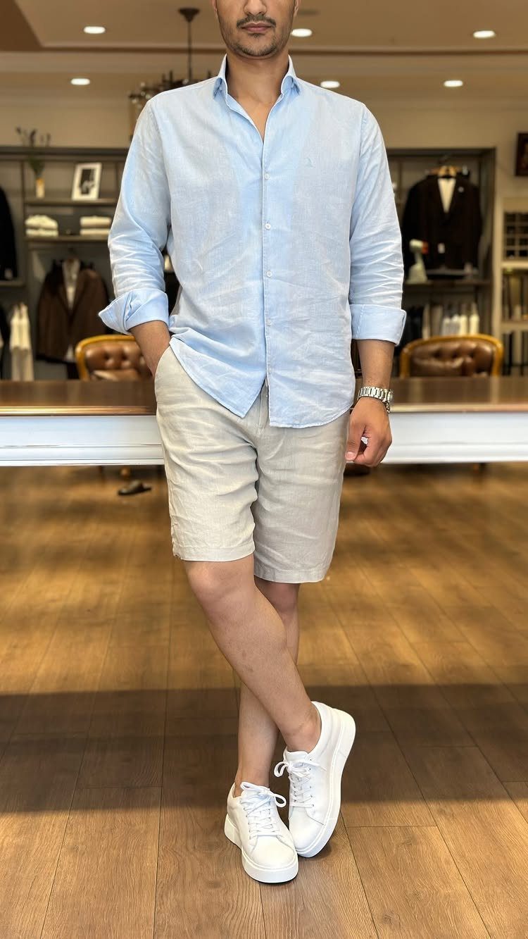 Man wearing a light blue shirt, beige shorts, and white sneakers in a store