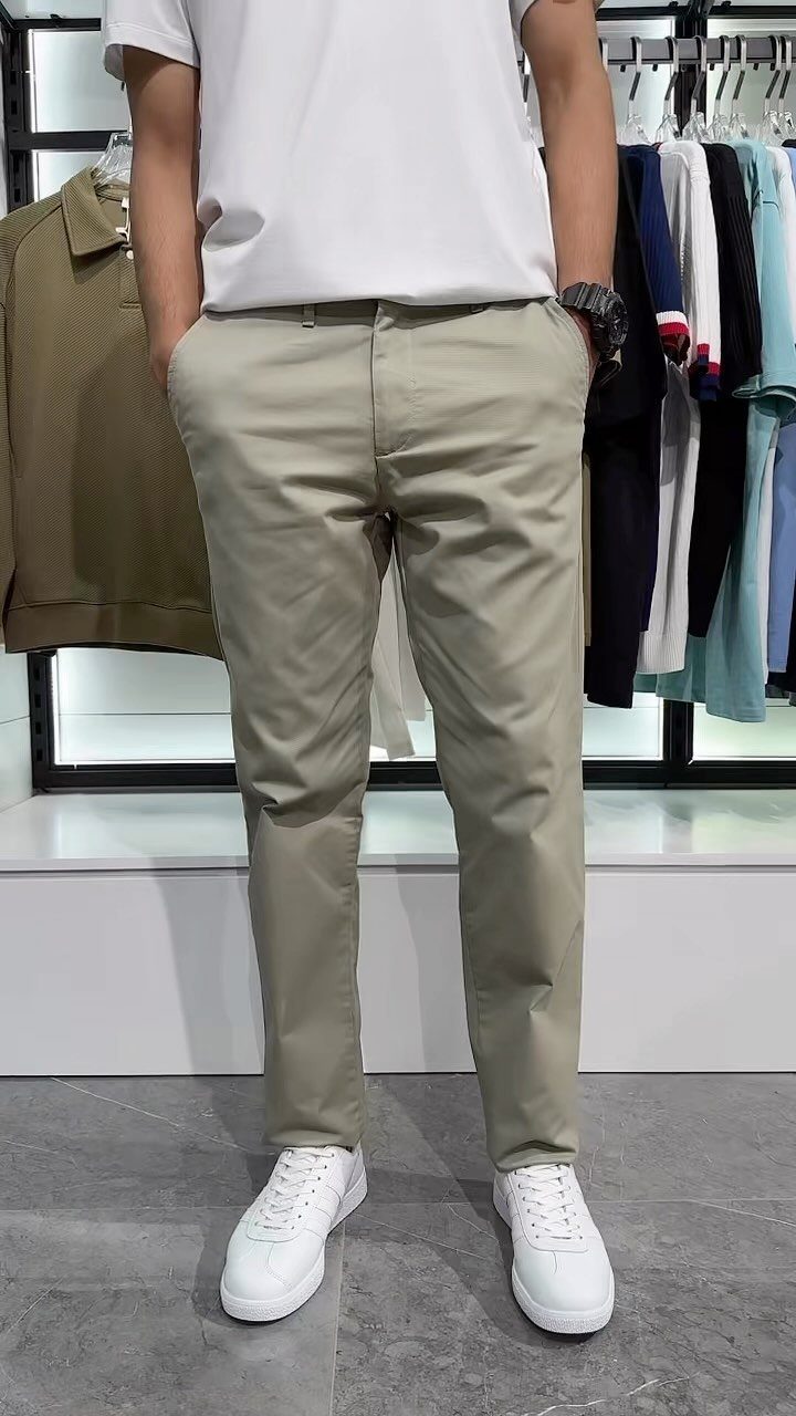 Person wearing khaki chino trousers, a white t-shirt, and white sneakers.