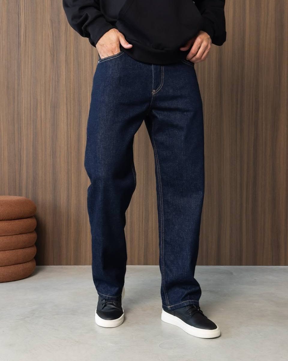 Person wearing a black hoodie, dark blue jeans, and black sneakers.