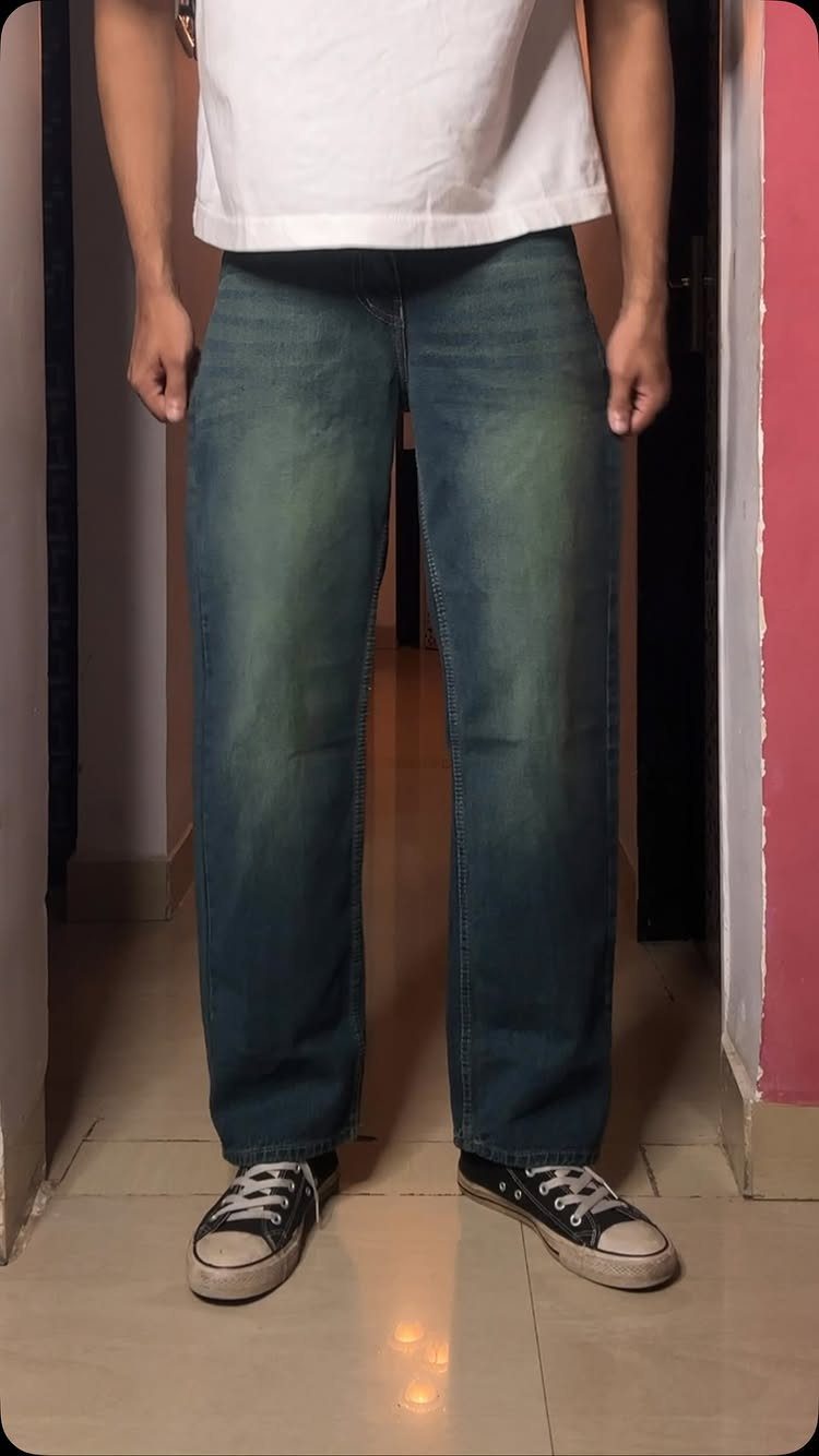 Person wearing blue straight-cut jeans, a white t-shirt, and black canvas sneakers.