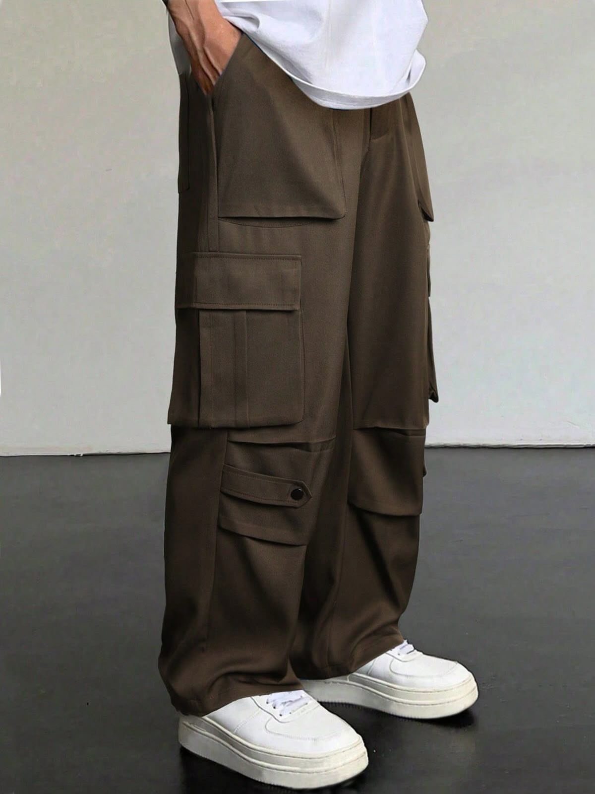 Olive-brown cargo pants with multiple utility pockets and white sneakers.