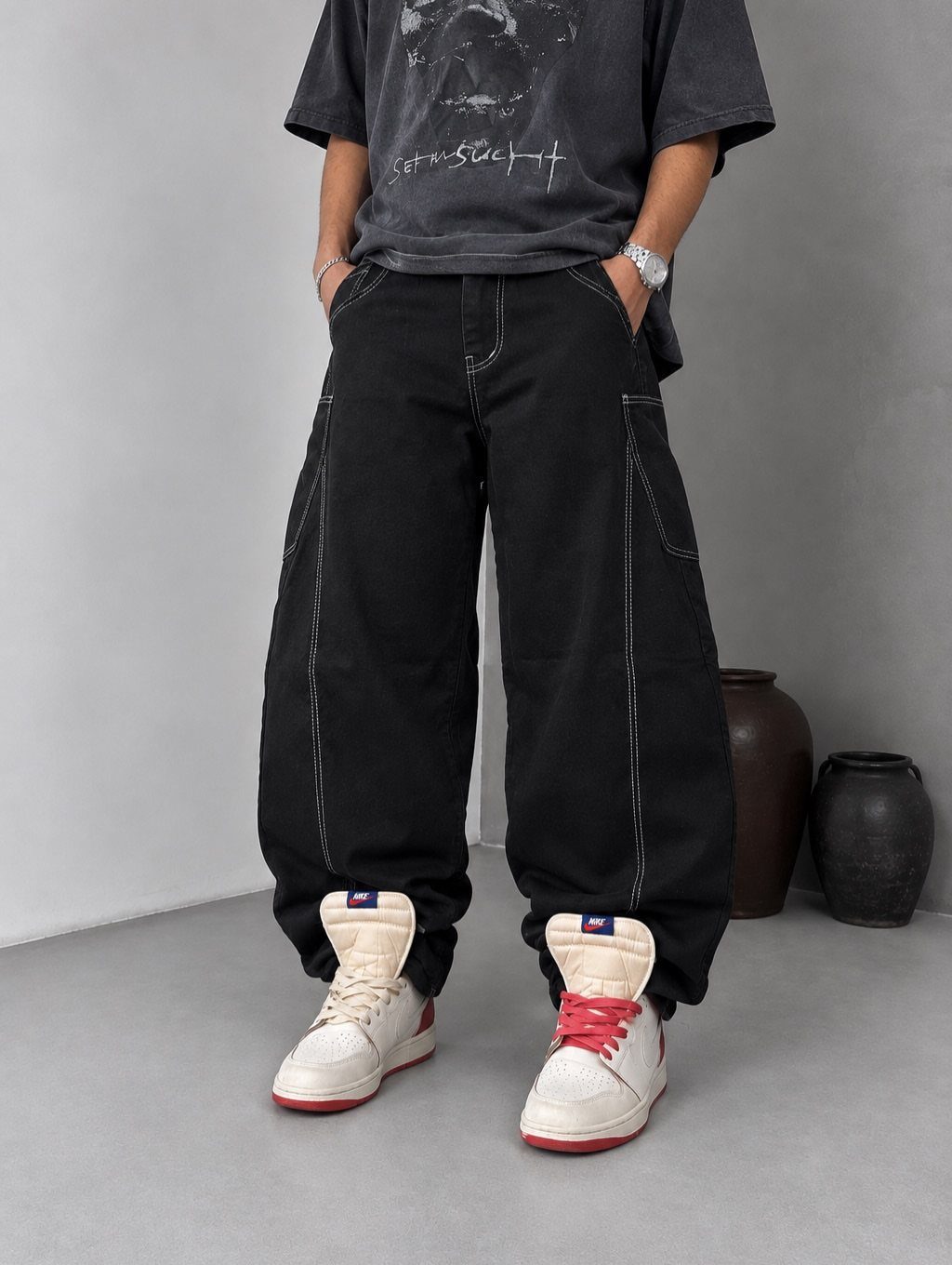 Black carpenter jeans with white contrast stitching and utility pockets on a person.