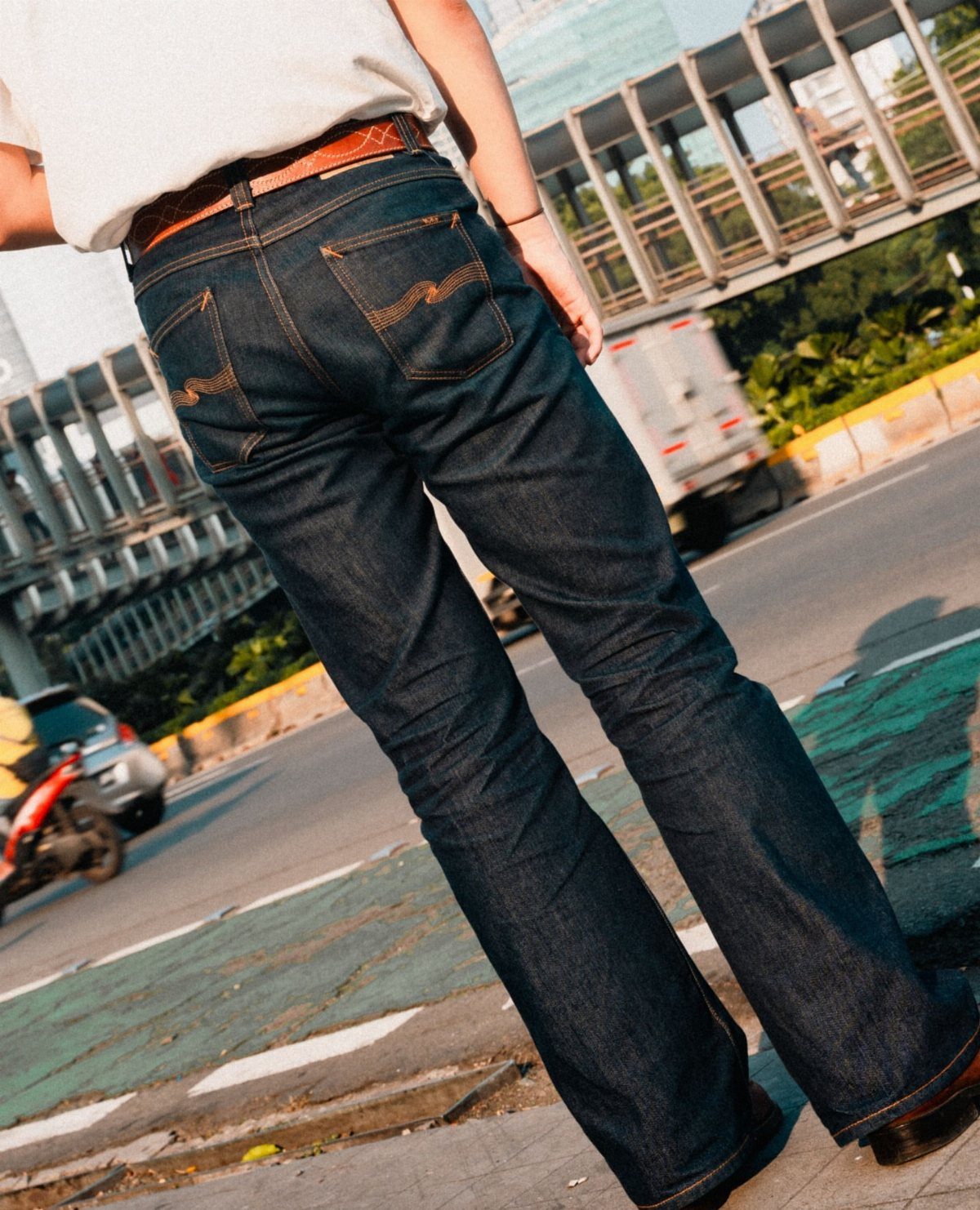 Dark blue straight-leg jeans worn by a person standing on a city street.