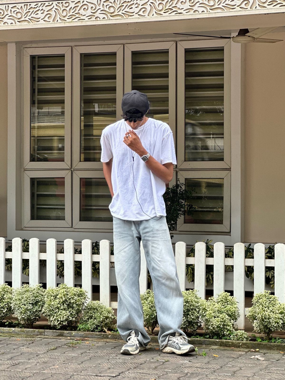 Person wearing wide-leg light blue jeans with chunky grey and white sneakers.